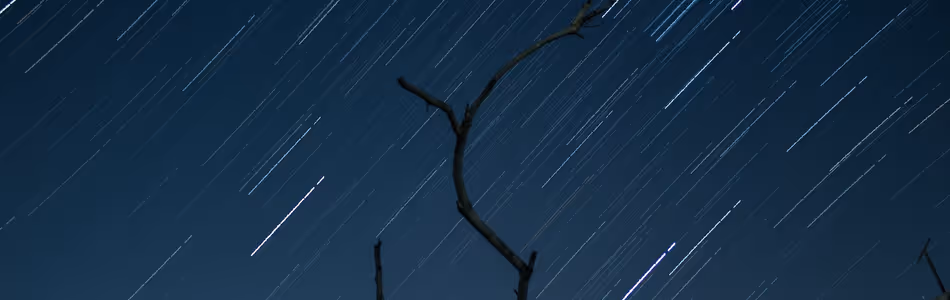 The night sky has streaks of light from a time-lapse photograph. 