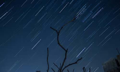 The night sky has streaks of light from a time-lapse photograph. 