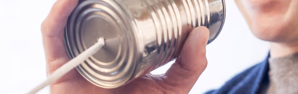 A man is speaking through a tin can phone