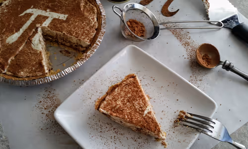 Tiramisu, a coffee flavoried dessert, as a pie decorated with the Pi symbol for Pi day.